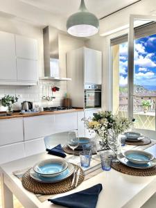 a white kitchen with a table with plates on it at Zoroastrohome Borgo Peretola Firenze Nord in Florence