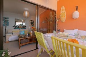 een woonkamer met een eettafel en een surfplank bij Luxury House Direct To The Beach & Natural Salt Pool in Tabaiba