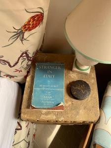 un livre assis sur une table à côté d'une lampe dans l'établissement Casa di Carolina Italian Holiday Home, à Pacentro