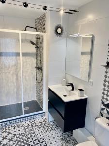 a white bathroom with a sink and a shower at Appt Cosy résidence Palmareda in Tarbes