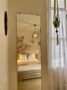einen Spiegel in einem Zimmer mit einem Bett und einem Fenster in der Unterkunft Appt Cosy résidence Palmareda in Tarbes