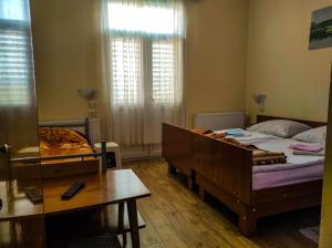 a bedroom with a bed and a table and a window at Vila Mon Repos in Soko Banja