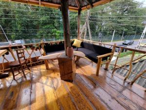 a porch with a couch and chairs on a wooden floor at The Empyrean Airport Transit Hotel in Katunayaka