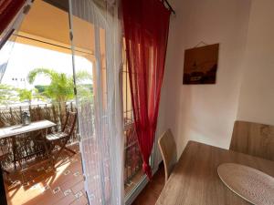 a room with a table and a window with a view of a balcony at Apartamento Rocio Al-Andalus in Chiclana de la Frontera