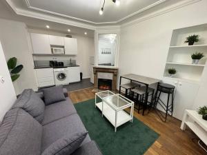 a living room with a couch and a table at Magnifique Appartement - Mairie 18ème in Paris