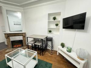 a living room with a table and a fireplace at Magnifique Appartement - Mairie 18ème in Paris