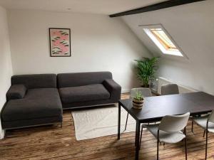 een woonkamer met een bank en een tafel bij Cozy attic apartment in Antwerpen