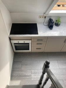 a kitchen with a stove and a counter top at Cozy attic apartment in Antwerp