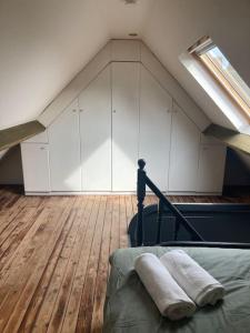 Pokój na poddaszu z łóżkiem i oknem w obiekcie Cozy attic apartment w Antwerpii