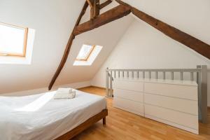 1 dormitorio con 1 cama blanca y 2 ventanas en Parenthèse Verte - petite maison à Guingamp, en Guingamp
