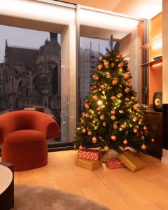 un arbre de Noël dans une pièce avec une chaise dans l'établissement Les 7 Anges - Cathédrale de Reims, à Reims
