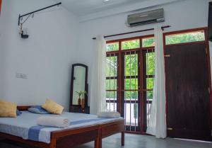 a bedroom with a bed and a large window at Cliff house in Weligama