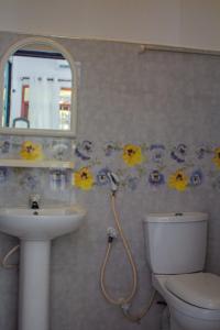 a bathroom with a sink and a toilet and a mirror at Cliff house in Weligama