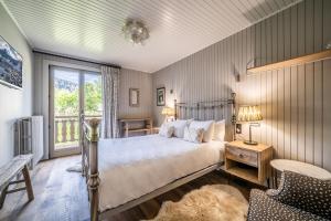 a bedroom with a bed and a chair and a window at Chalet La Rose de Clairiere Morzine - BY EMERALD STAY in Morzine