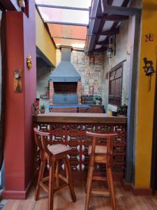 a kitchen with a bar with stools and a stove at Mi lugar Vintage Hostal - calor de hogar! in Asuncion