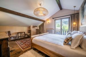 Un dormitorio con una cama grande y una mesa. en Chalet La Rose de Clairiere Morzine - BY EMERALD STAY, en Morzine