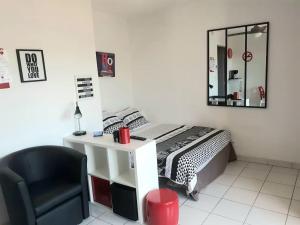 a bedroom with a bed and a desk and a chair at studio nimes costieres loggia parking in Nîmes