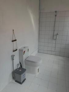 a white bathroom with a toilet and a shower at Seashell Guesthouse, bar and tattoos in Koh Rong Sanloem