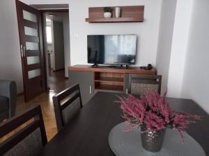 a dining room with a table and a tv at Nowogrodzka Central Apartment in Warsaw