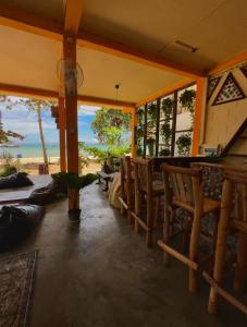 a dining room with chairs and a view of the ocean at Seashell Guesthouse, bar and tattoos in Koh Rong Sanloem +22 photos