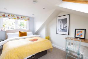a bedroom with a bed and a window and a chair at Pure B - Welcoming Bath City 3 Bed House Free Parking & Wifi in Bath