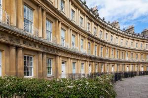 a large building with a fence in front of it at Pure B - Welcoming Bath City 3 Bed House Free Parking & Wifi in Bath