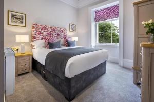 sypialnia z dużym łóżkiem i oknem w obiekcie Waterfoot Park w mieście Pooley Bridge