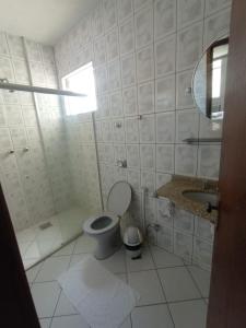 a white bathroom with a toilet and a sink at HOTEL DONA JOSA in Carmo do Cajuru