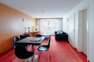 a room with a table and chairs and a couch at CERISE Bordeaux Mérignac Aéroport in Mérignac