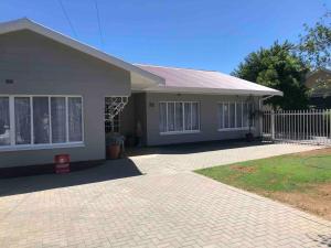 a house with a white fence in front of it at House Fynbos, 4 Bedroom house in Bloemfontein