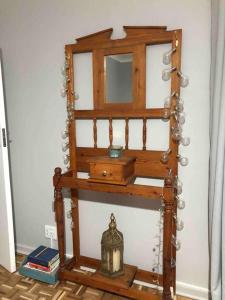 a wooden shelf with a mirror in a room at House Fynbos, 4 Bedroom house in Bloemfontein