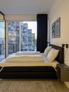 a bedroom with a large bed with a large window at Chic Atelier with Breathtaking Waterfront in Copenhagen