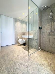 a bathroom with a shower and a toilet and a sink at Chic Atelier with Breathtaking Waterfront in Copenhagen