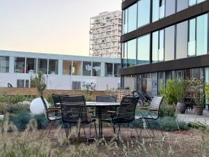 een tafel en stoelen voor een gebouw bij Chic Atelier with Breathtaking Waterfront in Kopenhagen