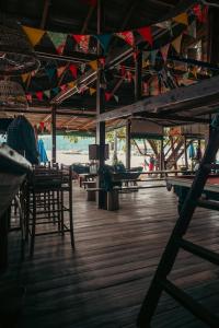 a room with tables and chairs on a wooden floor at Easy Tiger Garden Bungalows - by Beach House Cambodia in Koh Rong Sanloem