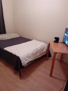 a small room with a bed and a desk with a laptop at une maison en ville in Saint-Denis