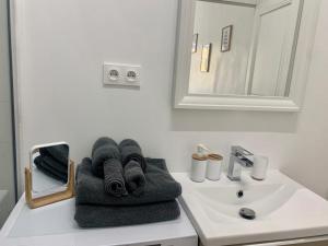 La salle de bains est pourvue d'un lavabo et de serviettes sur un comptoir. dans l'établissement Sublime Appartement 2 pièces au cœur de la Vieille Ville, à Nice