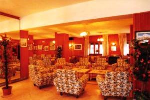 a large room with chairs and a table and a room with at Hotel Savoia Debili in Sauze dʼOulx