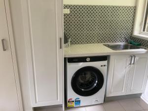 a washing machine in a kitchen with a sink at Warburton Waterfalls in Warburton