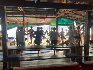 un grupo de personas de pie alrededor de una mesa con sus manos en Easy Tiger Garden Bungalows - by Beach House Cambodia, en Koh Rong Sanloem