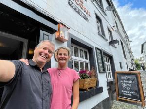 a man and a woman standing in front of a building at The Unicorn, Ambleside in Ambleside