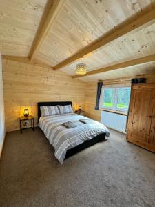 Glenariff的住宿－Glenariff Forest Larch Cabin，木制客房内的一间卧室配有一张大床