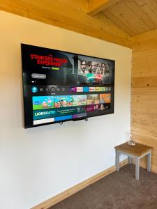 a flat screen tv hanging on a wall at Glenariff Forest Larch Cabin in Glenariff