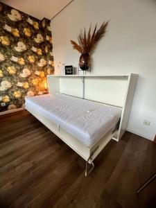 a white bed in a room with a wall at Wohnen im Schwarzwald mit Panoramablick in Bad Herrenalb