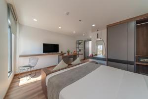 um quarto com uma cama grande e uma televisão em Khang's House em Nha Trang