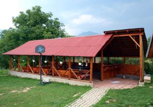 a large wooden pavilion with a red roof at Pension Zamolxe in Sarmizegetusa