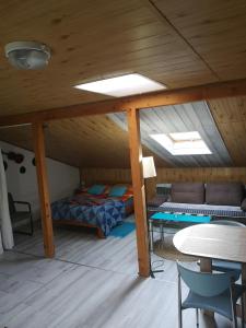 um quarto com duas camas e uma mesa num sótão em Apartament fort Owcza Góra na poddaszu em Klodzko