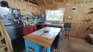 uma cozinha com uma mesa de madeira e um frigorífico em Refugio Costa Lenca em Lenca