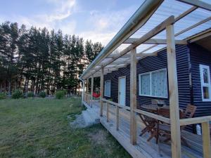 uma cabina com um deque com uma mesa e um banco em Refugio Costa Lenca em Lenca