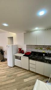 cocina con armarios blancos y nevera blanca en Apartamento Xavier 15, en Río de Janeiro